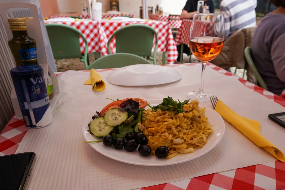 Bacalhau à Brás op een terras in Alfama in Lissabon