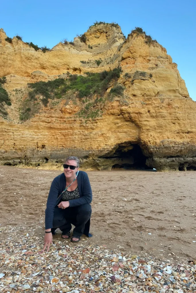 Co op zoek naar mooie schelpen op het strand in de Algarve